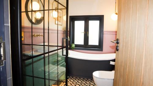 a bathroom with a toilet and a sink and a mirror at Boutique home near Chichester centre in Chichester