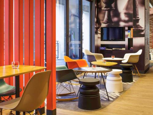 a room with tables and chairs and a tv at ibis Versailles Château in Versailles