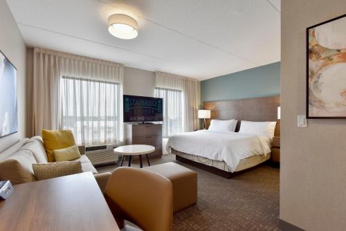 a hotel room with a bed and a living room at Staybridge Suites - Waterloo - St. Jacobs Area in Waterloo