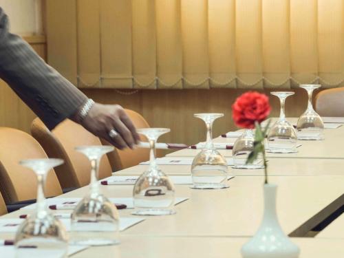 a table with wine glasses and a red rose on it at Mercure Ismailia Forsan Island in Ismailia