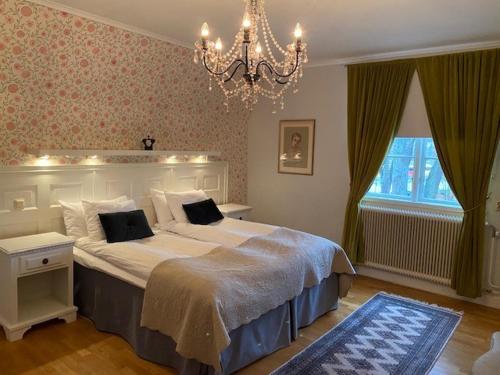 a bedroom with a large bed and a chandelier at Slottshotellet in Kalmar