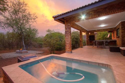 a swimming pool in front of a house at Shades of Nature in Marloth Park