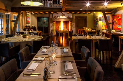 a restaurant with long tables and chairs and a fireplace at de Bosch in Lummen