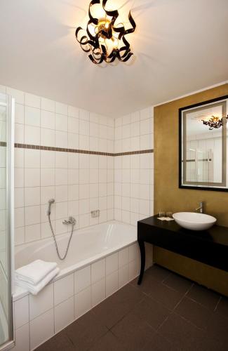 a bathroom with a bath tub and a sink at Schloss zu Hopferau in Hopferau