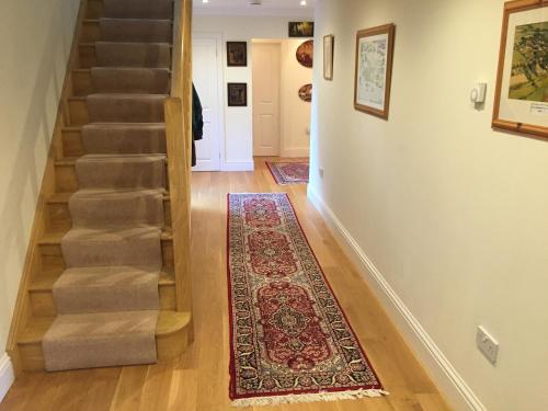 a hallway with stairs and a rug on the floor at Riverdown in Topsham