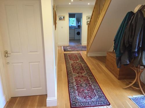 a hallway with a white door and a rug at Riverdown in Topsham