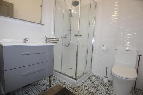 ein weißes Bad mit einer Dusche und einem WC in der Unterkunft Studio proche de la mer in Portel-des-Corbières