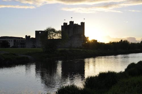 a castle sitting on the side of a river at Highfield House Guesthouse in Trim