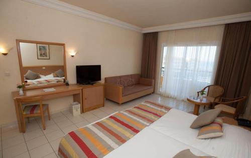 a large hotel room with a bed and a television at Hotel Nour Palace Resort & Thalasso Mahdia in Mahdia