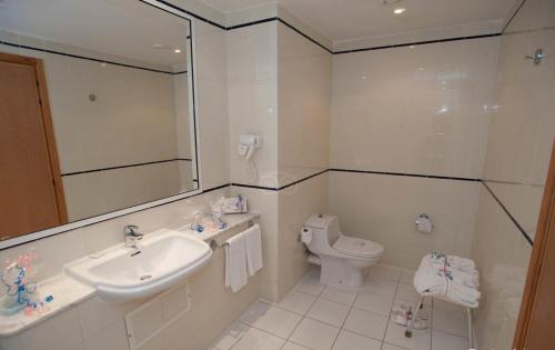 a white bathroom with a sink and a toilet at Hotel Nour Palace Resort & Thalasso Mahdia in Mahdia