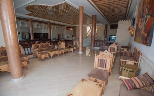 an empty restaurant with wooden tables and chairs at Hotel Nour Palace Resort & Thalasso Mahdia in Mahdia