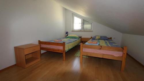sypialnia z dwoma łóżkami i oknem w obiekcie Apartments Ravlic w mieście Malinska