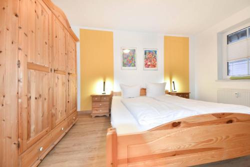 a bedroom with a large bed with a wooden door at Villen am Buchenpark 08 in Heringsdorf