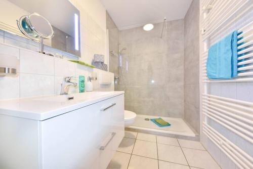 a white bathroom with a sink and a toilet at Villen am Buchenpark 08 in Heringsdorf