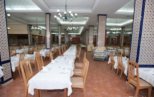 a dining room with white tables and chairs at Hotel Nour Palace Resort & Thalasso Mahdia in Mahdia