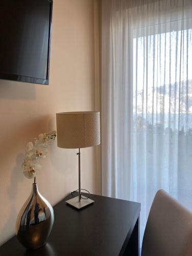 a room with a table with a lamp and a window at Hotel Villa Smeralda in Malcesine