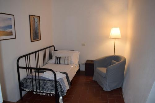a bedroom with a bed and a chair and a lamp at Tenuta della Selva in Murlo