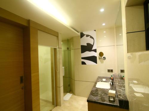 a bathroom with a shower and a sink and a mirror at The Sonnet Jamshedpur in Jamshedpur