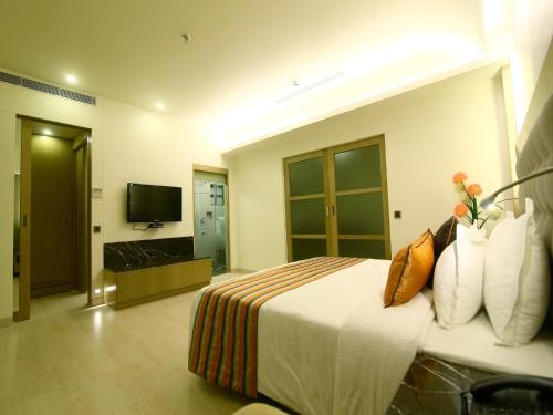 a hotel room with a bed and a television at The Sonnet Jamshedpur in Jamshedpur