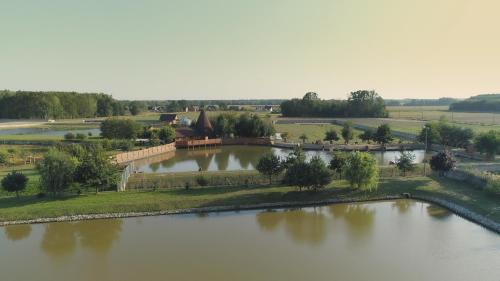 an aerial view of a large lake with a building at Tatarska Zagroda - Agroturystyka Dolina Baryczy Noclegi - Domek Jelonek in Krośnice