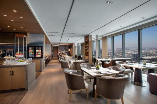 a restaurant with tables and chairs and windows at Crowne Plaza Shenzhen Nanshan by IHG in Shenzhen