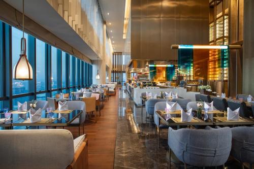 a restaurant with tables and chairs and large windows at Crowne Plaza Shenzhen Nanshan by IHG in Shenzhen