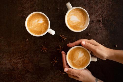 Zwei Hände halten zwei Tassen Kaffee auf einem Tisch in der Unterkunft Hotel La Chancla in Málaga