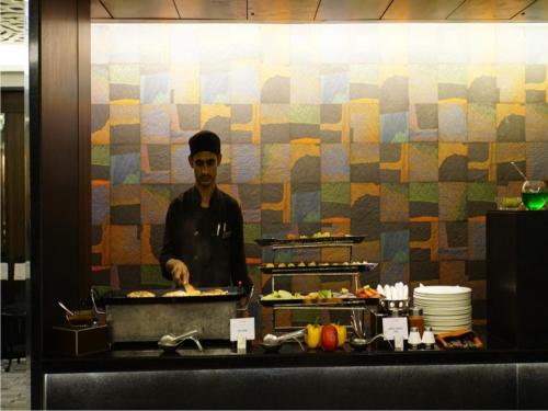 a man standing in a kitchen preparing food at The Sonnet Jamshedpur in Jamshedpur