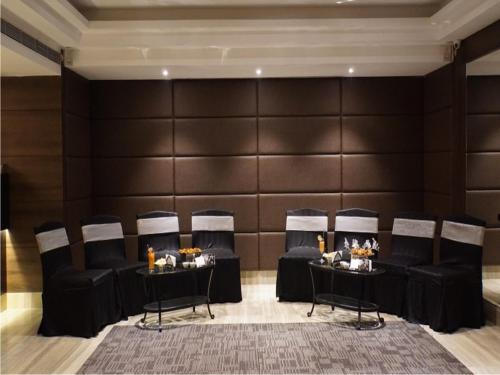 a conference room with black chairs and a wall at The Sonnet Jamshedpur in Jamshedpur