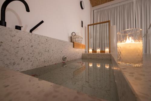a candle in a glass vase sitting on a counter at Kouros Exclusive Hotel & Suites - Adults Only in Faliraki