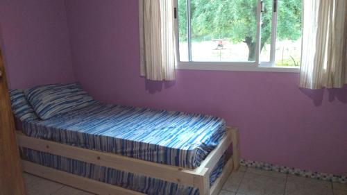 a small bed in a room with a window at Susurro de Montaña (TIERRA SANTA) in San Lorenzo
