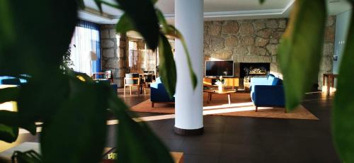 a living room with blue chairs and a fireplace at Belmonte Sinai Hotel in Belmonte
