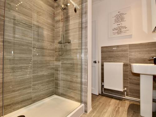 ein Badezimmer mit Dusche und Waschbecken in der Unterkunft A Character Cottage in Historical Canterbury in Canterbury