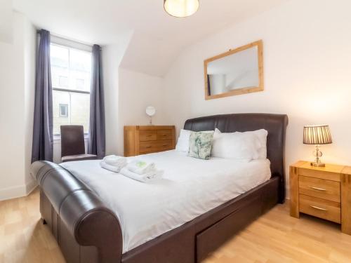 - une chambre avec un grand lit et une fenêtre dans l'établissement Bright and Cosy Flat at the Heart of the Old Town, à Édimbourg