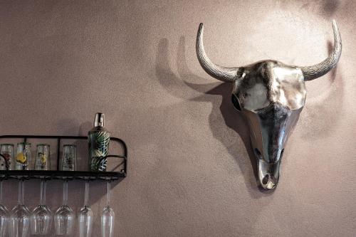 a bull skull hanging on a wall next to a shelf at GMOAHOUSE in Oggau