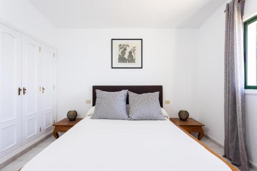 a bedroom with a white bed and a window at Villa Privada Mirador de La Gomera con jacuzzi in Puerto de Santiago
