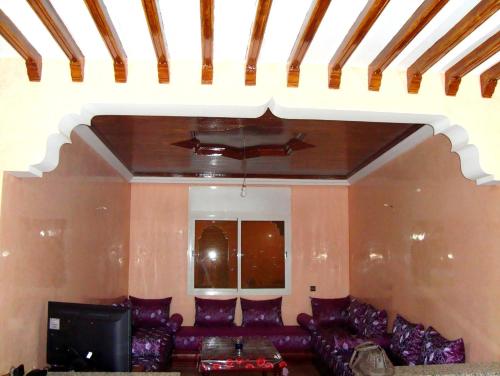 een woonkamer met een bank en een tv bij Yasmine Appartements in Temara