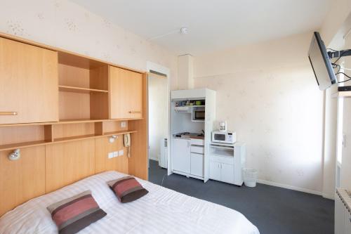 Cette petite chambre comprend un lit et un four micro-ondes. dans l'établissement Hotel Bellevue, à Chambon-sur-Lac