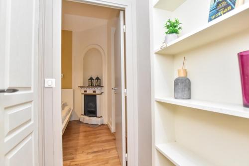 een hal met een open haard in een huis met witte planken bij CMG Résidence Réaumur in Parijs