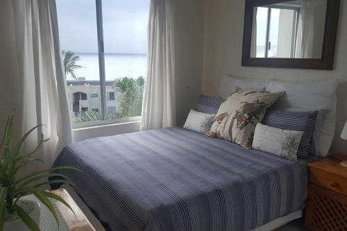 a bedroom with a bed with a view of the ocean at Laguna La Crete Beach Apartment 206 in Margate