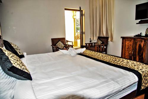 a bedroom with a large white bed with a cheetah at Omak Tiger Seven in Sawāi Mādhopur