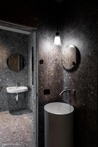a bathroom with a sink and a shower and a mirror at Relais Villa Margherita in Longiano