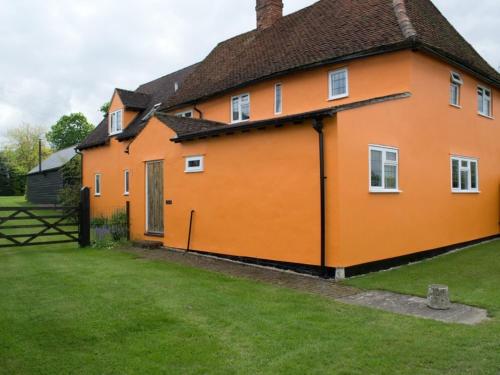 una gran casa naranja con un patio verde en Woodview B&B Colchester en Birch