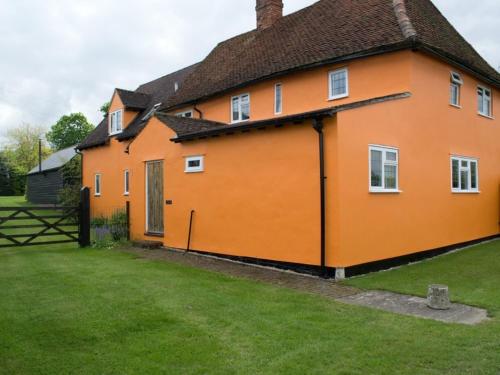 a large orange house with a green yard at Woodview B&B Colchester in Birch
