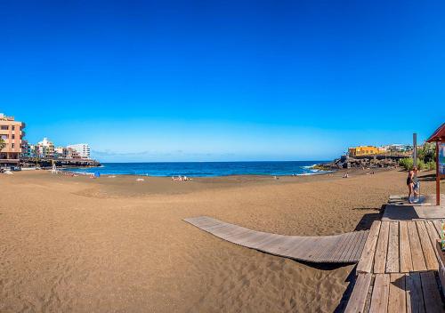 uma praia de areia com um passeio marítimo e o oceano em Golden Apartment em La Garita