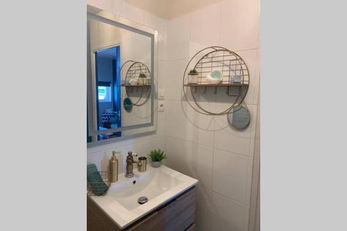 a bathroom with a sink and a mirror at Elégance Art Déco en bord de Loire in Blois