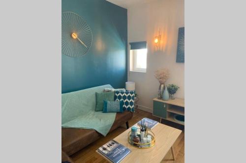 a living room with a couch and a table at Elégance Art Déco en bord de Loire in Blois