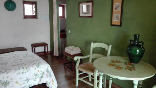 Zimmer mit einem Tisch und Stühlen sowie einer Vase auf einem Tisch in der Unterkunft La Escuela del Campo in Setenil de las Bodegas