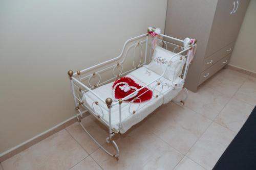 a baby crib with a red blanket on it at Chrysiida Apartment in Dhafnés