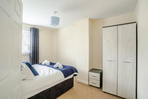 een slaapkamer met een bed, een kast en een raam bij Sleep at The Twyn - TV in Every Bedroom! in Swansea